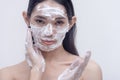 A studio picture of a transwoman with her face covered in foamy and bubbling soap. Beauty products and cosmetics endorser. Studio Royalty Free Stock Photo