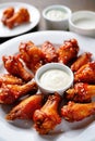 Studio plate of glazed chicken wings with rich sauce and dips, arranged Royalty Free Stock Photo