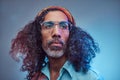 Studio portrait of African Rastafarian male wearing a blue shirt and beanie.