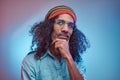 Studio portrait of African Rastafarian male wearing a blue shirt and beanie.