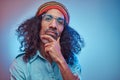 Studio portrait of African Rastafarian male wearing a blue shirt and beanie.