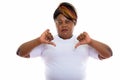 Studio shot of fat black African woman giving thumbs down ready Royalty Free Stock Photo