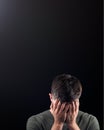 Studio Portrait Of Ashamed Young Man Covering Face With Hands