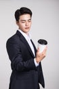 Studio portrait of an Asian business man posing with a disposable coffee cup Royalty Free Stock Photo