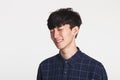 A studio portrait of an Asian young man making a happy smile