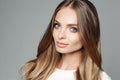 Studio portrait of an attractive blond woman with long thick hair and low-key makeup, wearing an elegant white blouse Royalty Free Stock Photo