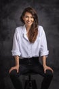 Smiling brunette businesswoman wearing white shirt and laughing against black background Royalty Free Stock Photo