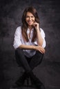 Smiling brunette businesswoman wearing white shirt and laughing against black background Royalty Free Stock Photo