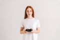 Studio portrait of attractive young woman playing video game with controller looking at camera on white Royalty Free Stock Photo