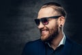 Studio portrait of bearded male dressed in a blue jacket and sunglasses. Royalty Free Stock Photo