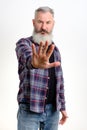 Studio portrait of bearded man in casual clothes shows hand stop sign, gesture no more, white background, copy space