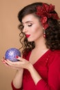 Studio portrait of a beautiful girl with blue Christmas ball in the hands of