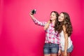 Adorable friendly girls taking self-portrait via film camera.