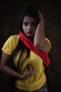 Studio portrait of a beautiful and young Indian Bengali female model in yellow tee shirt and jeans hot pat Royalty Free Stock Photo