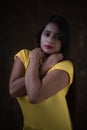 Studio portrait of a beautiful and young Indian Bengali female model in yellow tee shirt and jeans hot pat Royalty Free Stock Photo