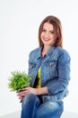 Studio portrait of beautiful young smiling woman holding houseplant Royalty Free Stock Photo