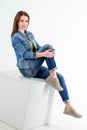 Studio portrait of beautiful young smiling woman wearing blue jeans and denim jacket Royalty Free Stock Photo