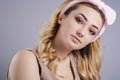 Studio portrait of a beautiful young woman with fluffy soft hoop on head that picks hair, fresh girl face with make up, the Royalty Free Stock Photo