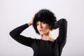 Studio portrait of beauty blond woman standing in black clothes and black fur hat Royalty Free Stock Photo