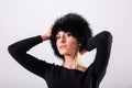 Studio portrait of beauty blond woman standing in black clothes and black fur hat Royalty Free Stock Photo