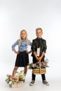 Studio portrait boy and girl dressed school uniform with greeting flower arrangements in wooden baskets congratulatory concept 