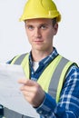 Studio Portrait Of Builder Architect Looking At Plans Against White Background