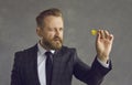 Studio portrait of businessman in formal wear aiming with dart holding focus