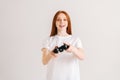 Studio portrait of cheerful attractive young woman playing video game with controller looking at camera on white Royalty Free Stock Photo