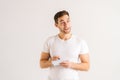 Studio portrait of cheerful pensive young man writing in copybook on white isolated background, looking away. Royalty Free Stock Photo