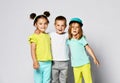 Full body shot of three children in bright clothes, two girls and one boy. Triplets, brother and sisters.