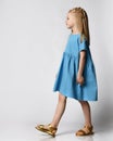 Studio portrait of a cute beautiful little girl in a blue summer dress on a white background. Royalty Free Stock Photo