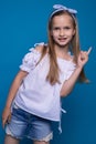 Studio portrait of cute funny little girl on background of blue wall. Royalty Free Stock Photo