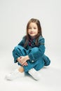 Studio portrait of a cute little girl. kids fashion child in denim pants and jacket and white sneakers Royalty Free Stock Photo