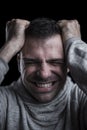 Portrait of a desperate man with hands on his head. Black background. Vertical Royalty Free Stock Photo