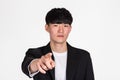 A studio portrait of an East Asian business man pointing at something