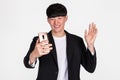 A studio portrait of an East Asian business man posing for various poses with a cellphone