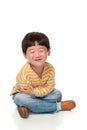 A studio portrait of an East Asian male child sitting and happy