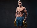 Ectomorph shirtless athletic male holds barbell weight.