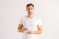 Studio portrait of excited young man writing in copybook with pen standing on white isolated background. Royalty Free Stock Photo