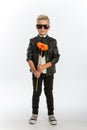 Studio portrait of fashionable blond caucasian boy with single gerbera flower, white background, copy space Royalty Free Stock Photo