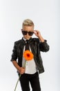 Studio portrait of fashionable blond caucasian boy with single gerbera flower, white background, copy space Royalty Free Stock Photo