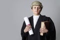 Studio Portrait Of Female Lawyer Holding Brief And Book