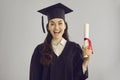 Studio portrait of funny excited college graduate holding diploma and smiling at camera Royalty Free Stock Photo