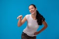 Studio portrait of a young beautiful woman in a white t-shirt against a blue wall background. People sincere emotions. Royalty Free Stock Photo