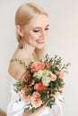 Attractive young woman posing over grey background with flowers Royalty Free Stock Photo