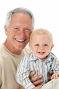 Studio Portrait Of Grandfather Holding Grandson