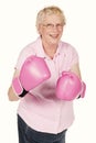 A studio portrait of a grandma wearing pink boxing gloves isolated on white. Royalty Free Stock Photo