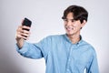 Studio portrait of a handsome asian man holding a smart phone