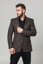 Studio portrait of handsome elegant young man in brown jacket po Royalty Free Stock Photo