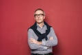 Studio portrait of handsome man wearing blue shirt and glasses posing on red background Royalty Free Stock Photo